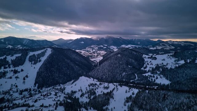 Aerial Hyperlapse of Winter Carpathian Landscape with Overcast Sky and Light on the Horizon.