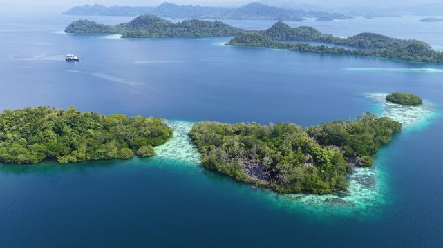 Shallow coral reefs fringe the beautiful islands of Pef, Raja Ampat, Indonesia. This region harbors spectacular marine biological diversity and is a popular destination for divers and snorkelers.