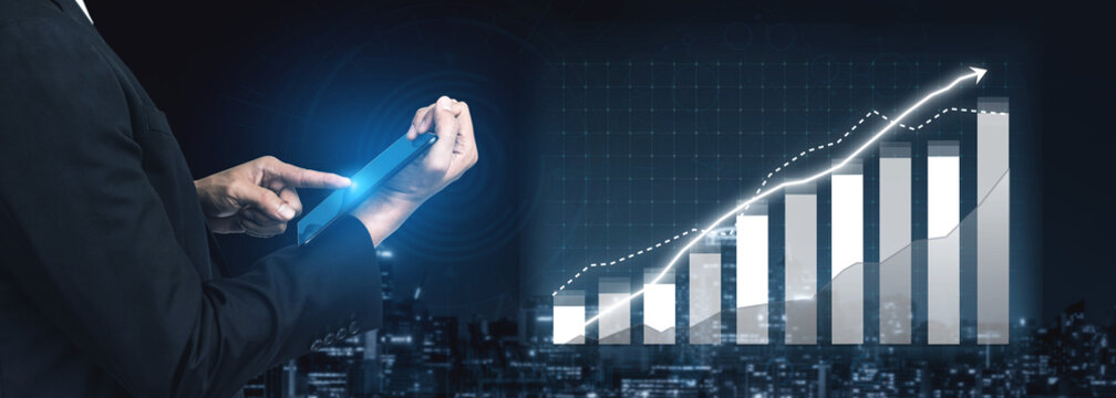 A businessman interacts with a digital tablet, analyzing financial data represented by a growing graph against a night city backdrop, showcasing modern technology. Impute - Powered by Adobe