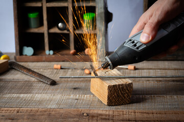 Cutting metal with a rotary precision tool in a workshop for craft tasks.