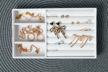 Jewelry collection arranged in a tray ready for selection on a woven surface