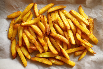 Crispy golden fries served on a white paper-lined tray during a casual meal at home or a diner in the afternoon