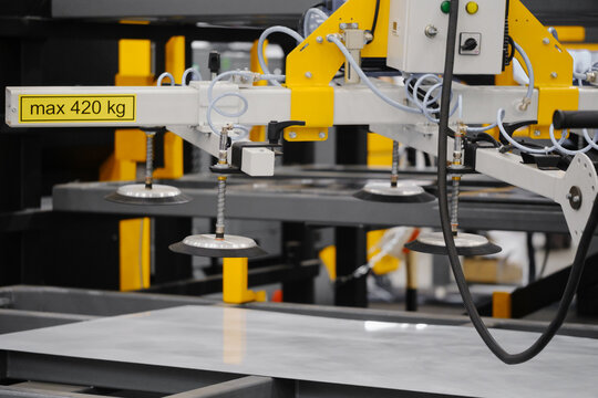 Vacuum lifting beam with multiple suction cups handling large sheet on automated material handling system in warehouse or cutting cell environment