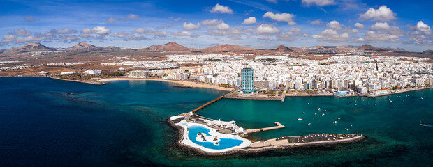 Aerial view of Arrecife, Lanzarote, curving around a turquoise bay. Islote de Fermina with white...