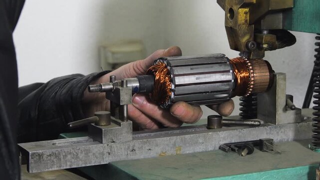 Hot staking process on commutator fusing machine during rewinding electric motor in repair shop
