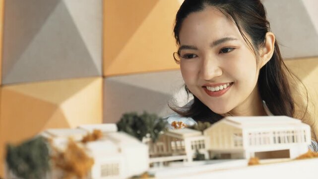 Skilled attractive architect engineer holds architect model while checking mistake point carefully. Project manager inspect architectural model by lifting left side and right side. Manipulator.