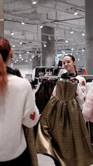 Obraz premium Two teenage friends are shopping for warm winter clothes.