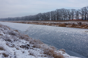 Winter river panorama with early ice cover, frazil ice streaks and frozen banks illustrating large river freeze up