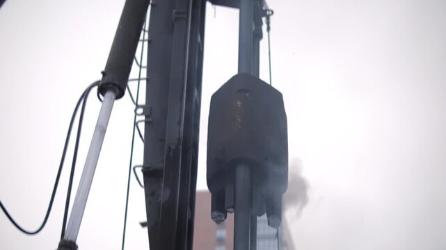Pile driving hammer operating at construction site in winter