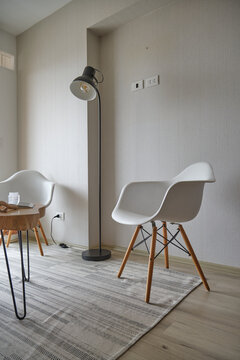 Minimalist living room interior featuring modern eames style chairs and floor lamp