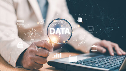 Data analysis and AI technology concept. Businessman using magnifying glass over digital data interface. Analytics, information security, artificial intelligence and smart business decision making.