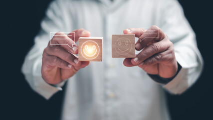 Customer satisfaction and feedback concept. Person holding wooden blocks with smile icons. representing positive experience, service quality, user review, rating and emotional connection in business.