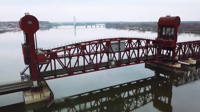 Aerial shot of a railroad drawbridge lifting or raising over the Mississippi River near Burlington, Iowa.