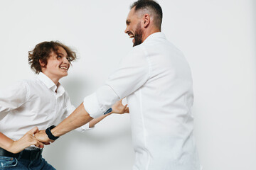 Obraz premium A professional man and colleague share a confident handshake in a bright studio. The moment shows positive emotions and professional energy against a solid color backdrop.