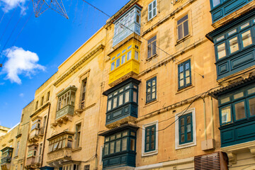 Fototapeta premium View of old stone buildings with traditional colorful wooden balconies in Valletta, Malta