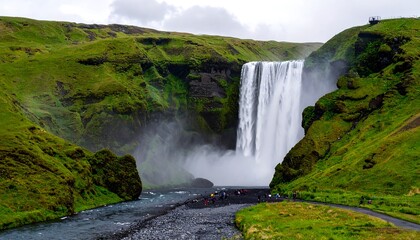 A majestic waterfall cascades down a rocky cliff face, surrounded by vibrant green hills and a cloudy sky. Small figures watch