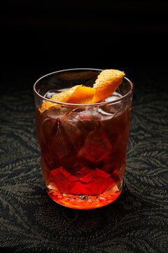 Sipping a refreshing cocktail with orange peel garnish at a stylish bar during a casual evening