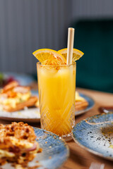 Refreshing orange juice served with breakfast at a cozy cafe featuring diverse dishes from various cuisines