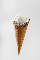 Enjoying a creamy scoop of ice cream in a waffle cone with a chocolate and coconut coating
