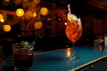 Enjoying summer cocktails at a lively bar with vibrant lights and delicious drinks