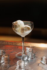 Gourmet dessert served in a glass bowl on a silver tray with ice cubes around it