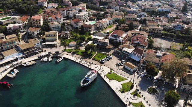 Aerial drone view of Kassiopi, coast sea village in northeast coast of Corfu island, Ionian Islands, Kerkyra, Greece in a summer sunny day, with marina, town, beach and castle, Greek landscape