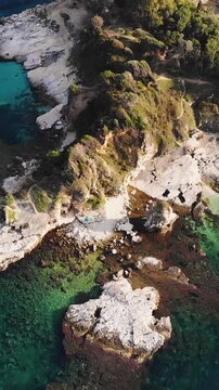 Aerial drone view of Kassiopi, coast sea village in northeast coast of Corfu island, Ionian Islands, Kerkyra, Greece in a summer sunny day, with marina, town, beach and castle, Greek landscape