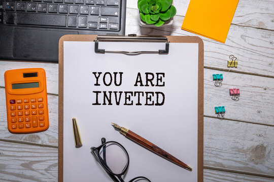 businessman holding a card with text YOU ARE INVETED