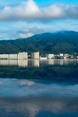 早朝の静かな琵琶湖　大津市のマンション群と雲が湖面に映る風景