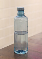plastic bottle filled with water on a wooden table.