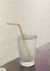 Cold water in a glass with a straw.