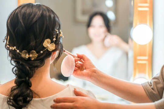 Bride putting on makeup in the bridal room
