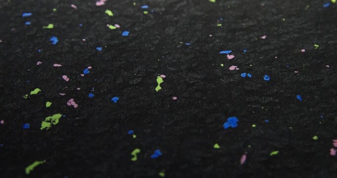 Colourful texture of a material made of recycled plastic. Waste pellets via sintering technique. Bright inclusions of recycled plastic granules. Sustainable material textures.