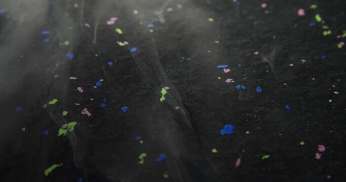 Colourful texture of a material made of recycled plastic. Waste pellets via sintering technique. Bright inclusions of recycled plastic granules. Sustainable material textures.