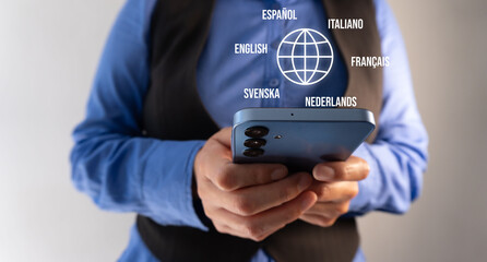 Close-up of a businesswoman holding a cell phone with a globe icon and several languages ​​around it. Online translation concept.