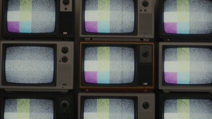 Grid of multiple vintage televisions displaying color test patterns and static noise