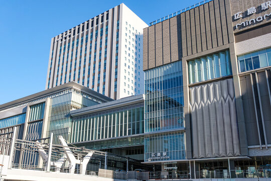 JR Hiroshima Station with street car running in the foreground during day time, which is an integrated facilities with shopping malls and street car terminus in Hiroshima, Japan on 22 Dec 2025