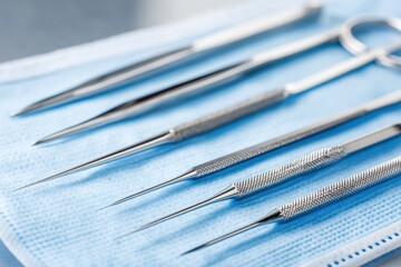 A sterile set of dental examination instruments arranged on a blue textured surface, showcasing precision tools for oral care
