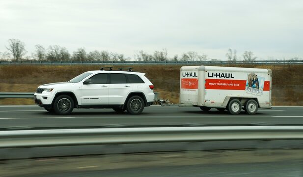 New Jersey, U.S - Jan 17, 2026 - A U-Haul trailer towed by Jeep Grand Cherokee SUV, promoting self-moving services and rental convenience.