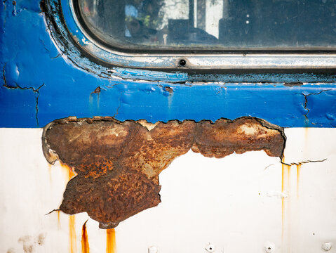 Peeling Paint on Old Metal Surface with Yellow Hinge and Rust Damage