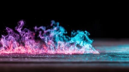 Fototapeta premium Colorful smoke swirls rising on a dark surface during a creative art project