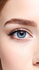 Fototapeta premium Close-up of a woman's face focusing on her bright blue eye and defined eyebrow with soft, fair skin visible