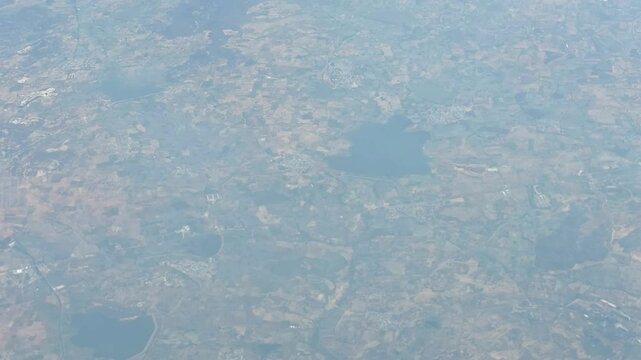 High-altitude view of a winding river flowing through expansive land, captured from an airplane window.