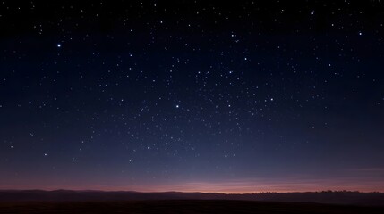 Fototapeta premium A vast clear night sky filled with countless twinkling stars above a dark tranquil horizon at twilight