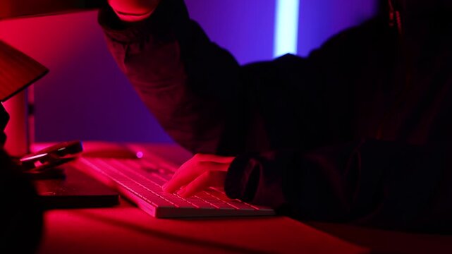 Kid hacker hacking computer. anonymous hacker wearing mask and black hoodie in dark room. online scam and cyber security threat.