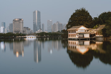 Fototapeta premium City Skyline and Traditional Pavilion Reflecting in Calm Lake - Huizhou West Lake