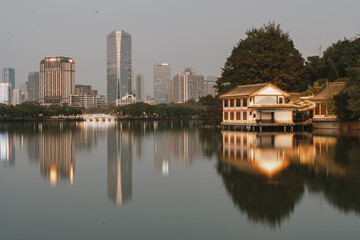 Fototapeta premium City Skyline and Traditional Pavilion Reflecting in Calm Lake - Huizhou West Lake