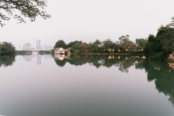 Obraz premium Serene Lake Reflection with City Skyline and Traditional Pavilion - Huizhou West Lake