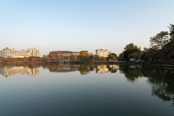 Fototapeta premium Serene Lake Reflection with Cityscape at Dusk, West Lake in Huizhou, Guangdong Province, Asia China, is a tourist attraction featuring ancient architecture