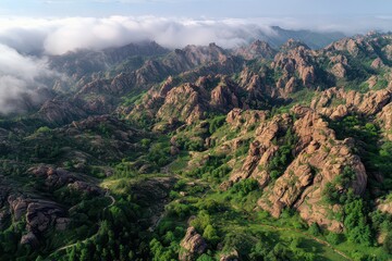 Aerial View of Brown Rocky Mountain Range with Green Vegetation under a Cloudy Sky Landscape in a Natural Outdoor Setting in Warm Lighting